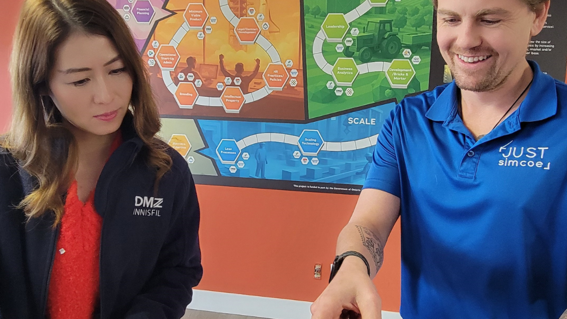 DMZ Innisfil graduates, Jennifer Ai (left) and Andrew de Jong (right) explore the new Entrepreneurial Journey Map, a tool designed to connect founders with local business support