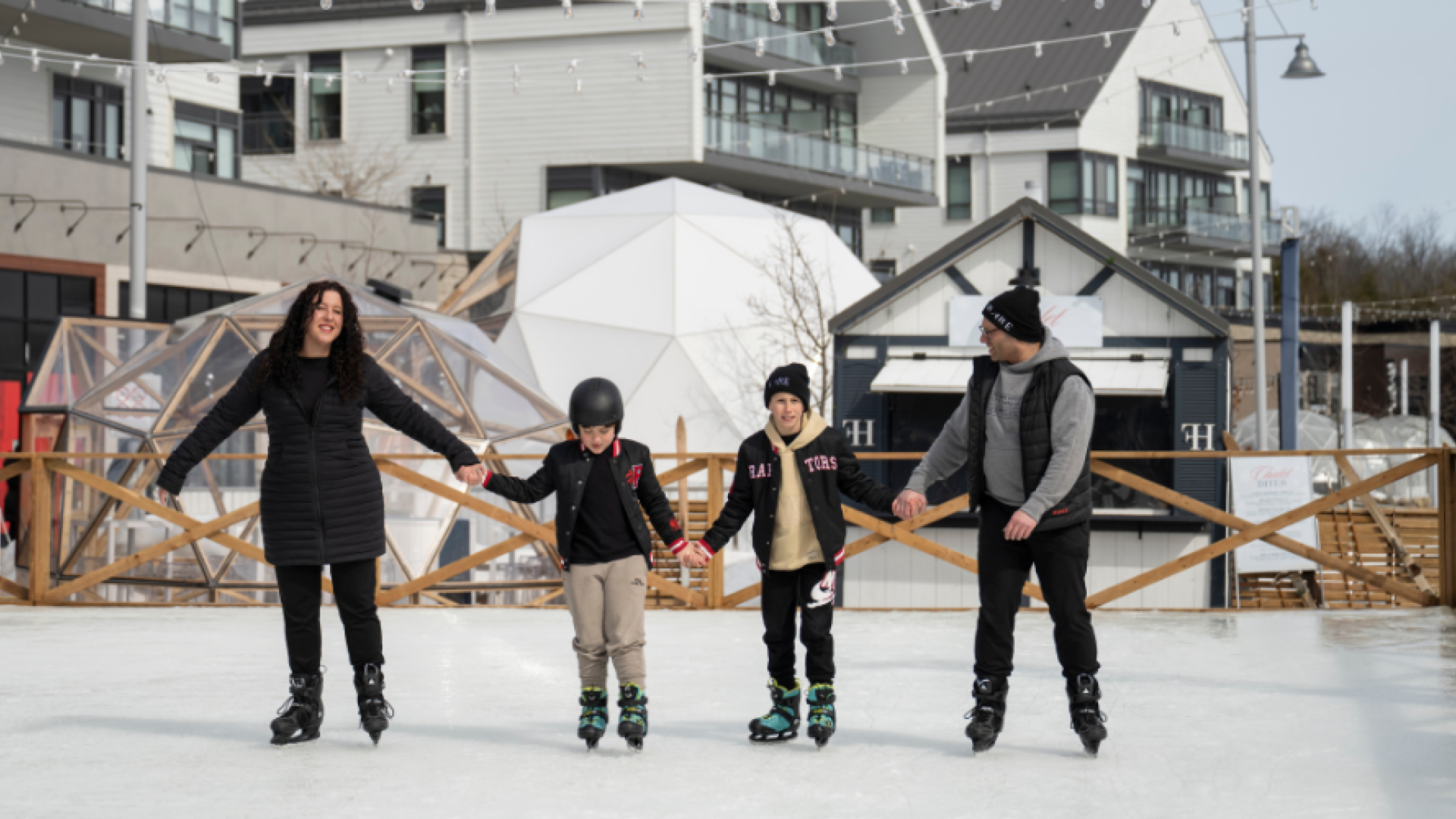 Family skating on the outdoor ice rink at Friday Harbour Resort in Innisfil