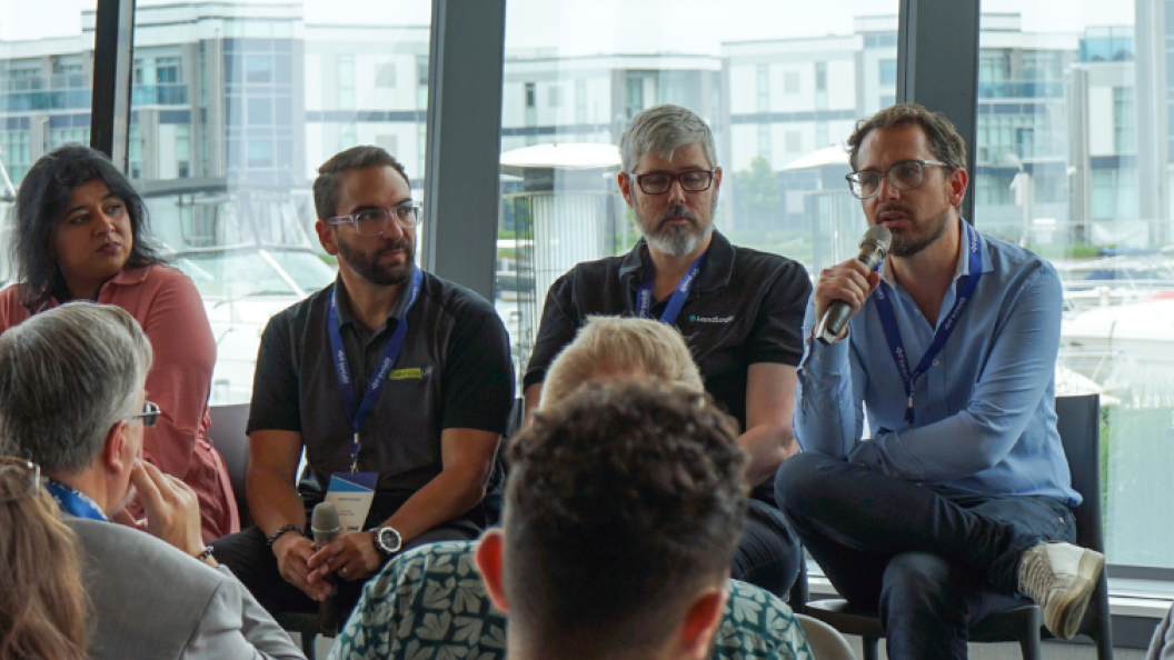 Group of panelists presenting to audience at a business conference