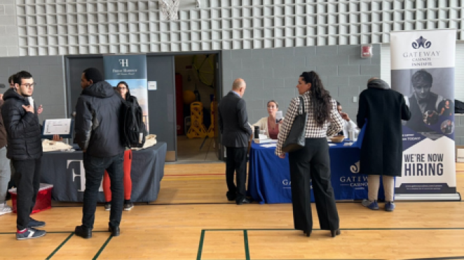 people a job fair with booths in a gymnasium