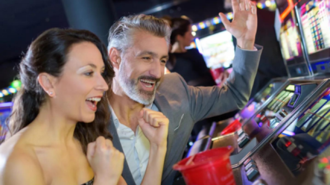 a man and a woman celebrating a win at an arcade game