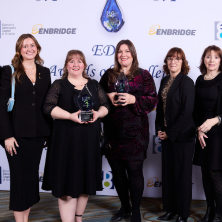 group of men and women standing together showing of the award they received
