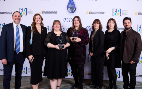 group of men and women standing together showing of the award they received